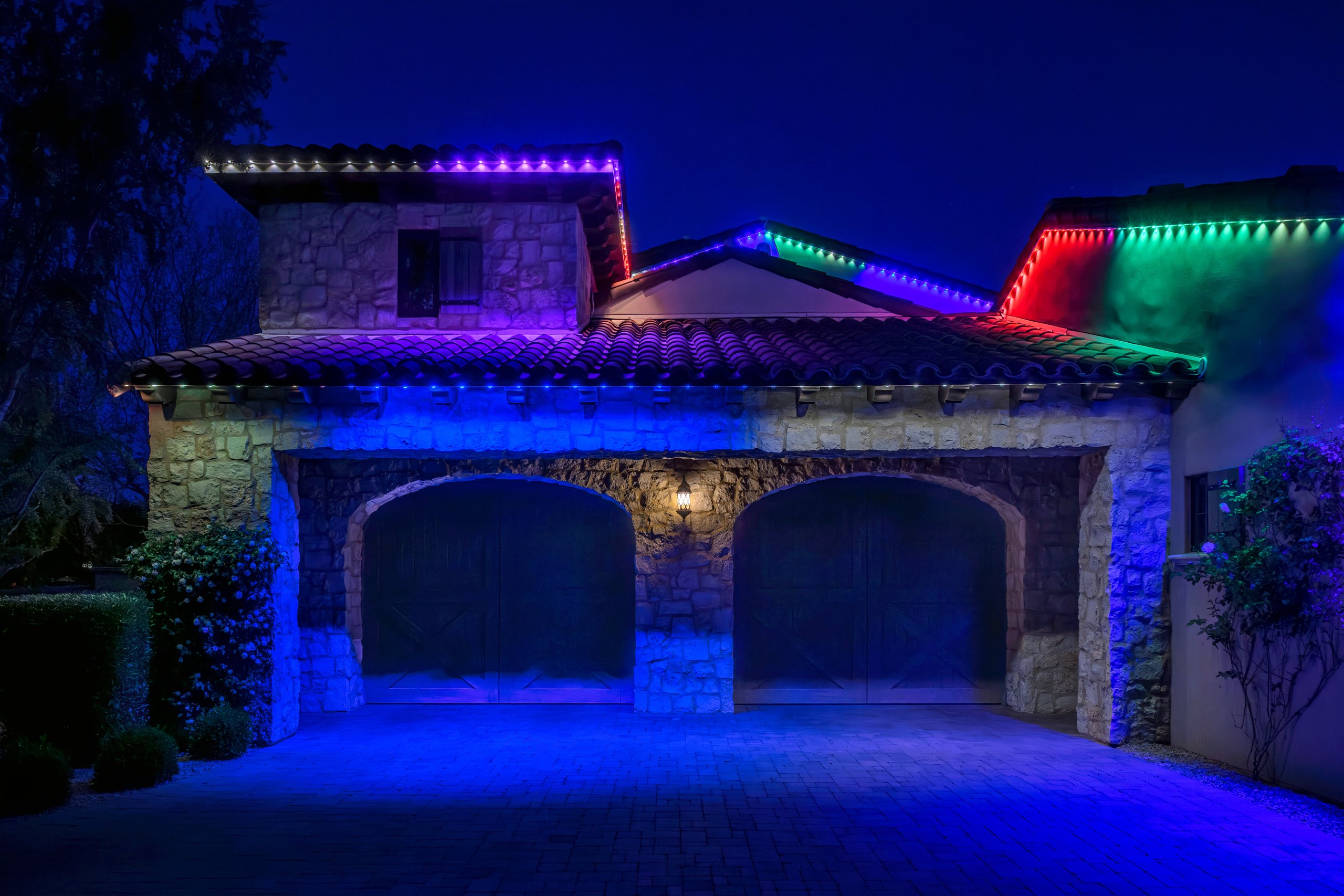 Multicolor permanent trim lighting on a stone home at night in Phoenix